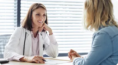 Female doctor touching female patient's face